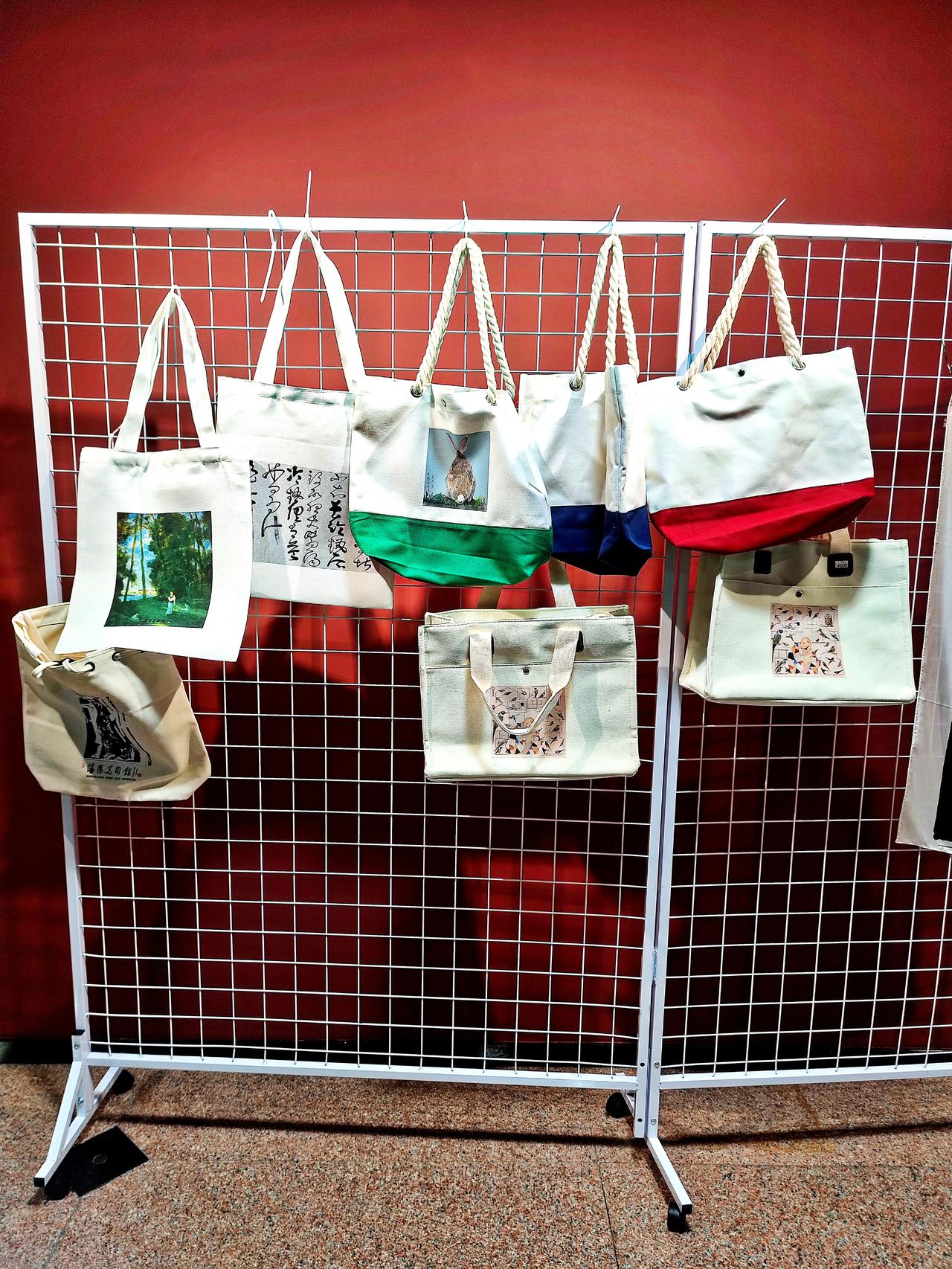 沈阳美术馆文创品一观。美术馆一楼大厅内，文创手提包和图画展示和出售，艺术美观，供