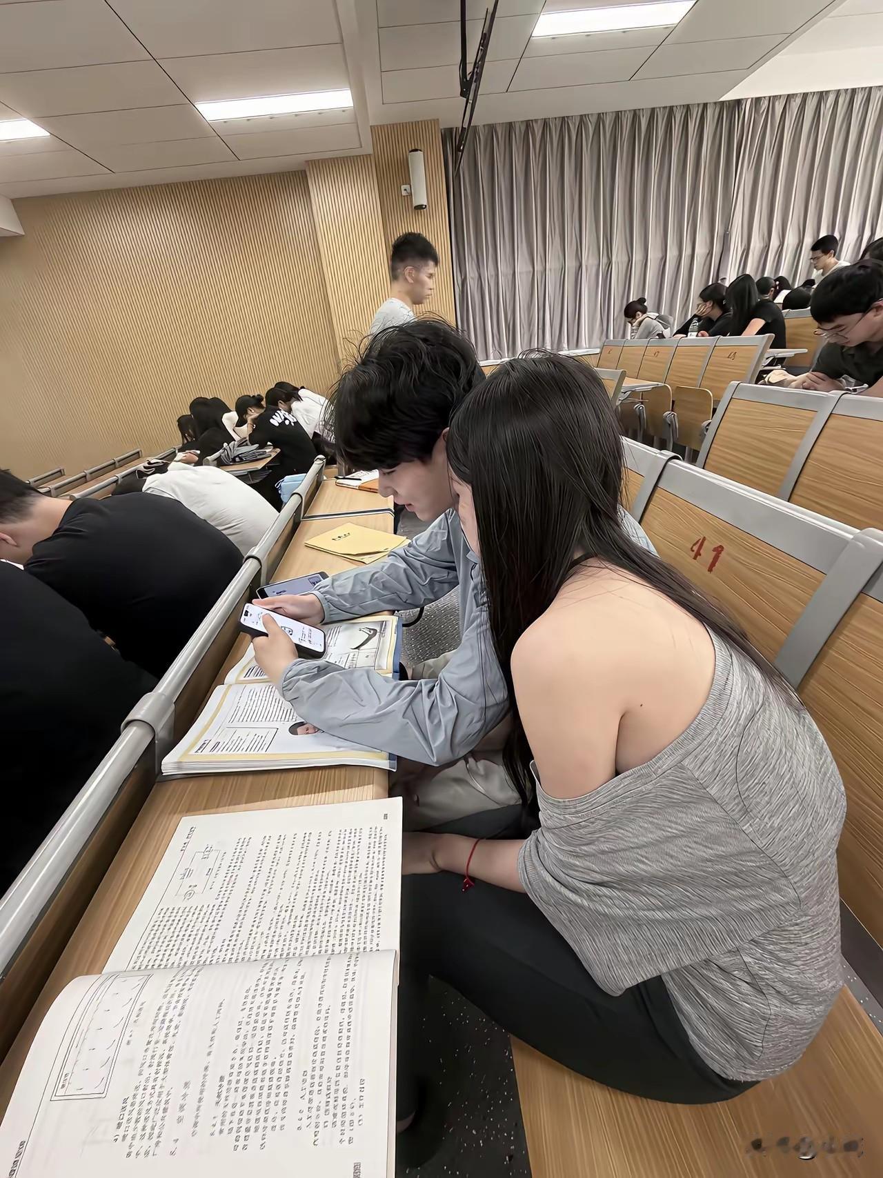 【书本是幌子，靠近才是目的。
外人只看见认真听课，
只有他们清楚屏幕里的秘密。