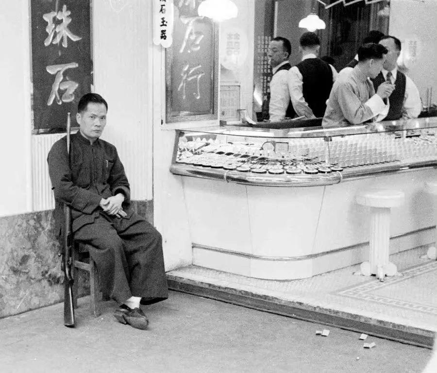 上个世纪50年代，香港街头珠宝店的保安，竟然持枪上岗，眼光犀利，始终注视店门口的