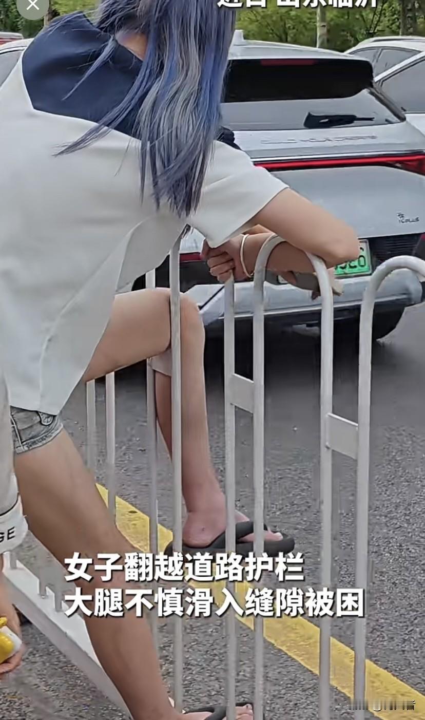 就为了省那几步路，她翻护栏结果大腿直接卡进缝隙，整个人悬在半空，疼得直叫 腿被死
