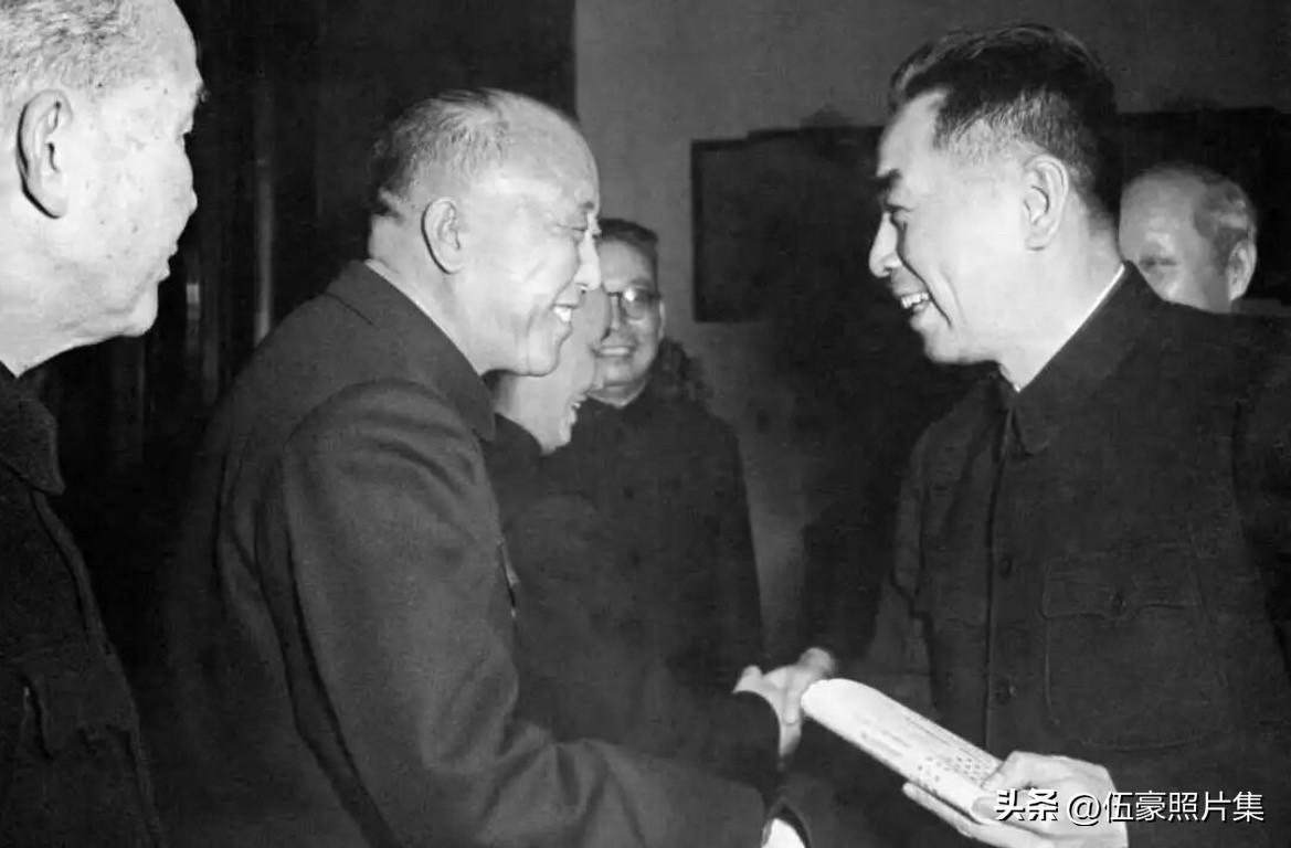 1955年，周恩来总理与卫立煌在某次会议期间握手交谈的场景。早在1955年初，中