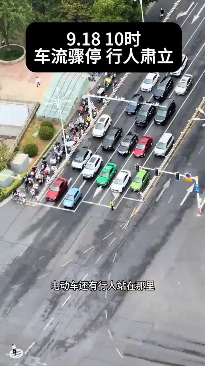9.1810时，车流骤停，行人肃立。电动车还有行人站在那里，他们就不动了。山河无