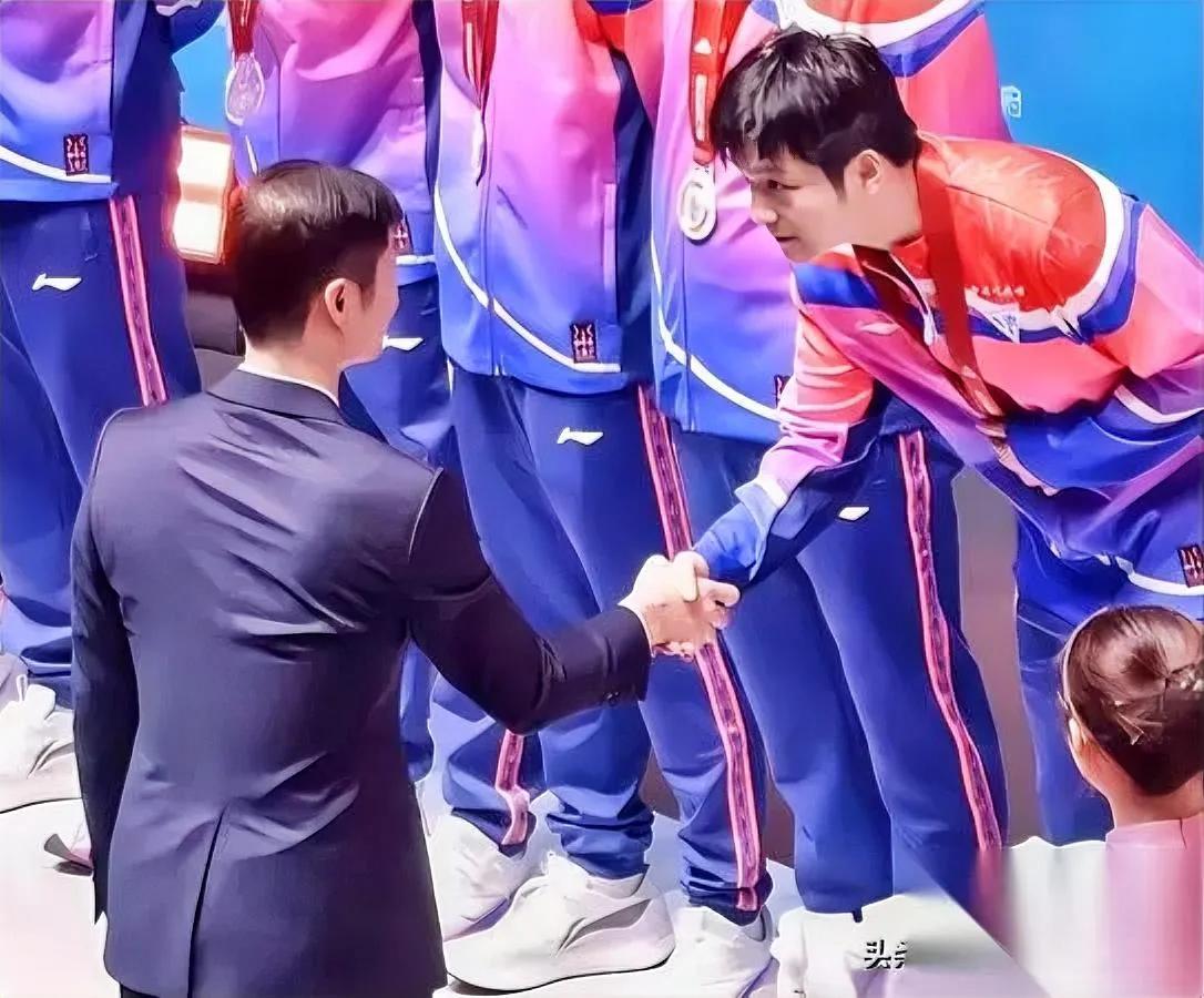 樊振东握手的样子

你注意过吗？

和别人都不一样——

王励勤颁奖时，旁人都是