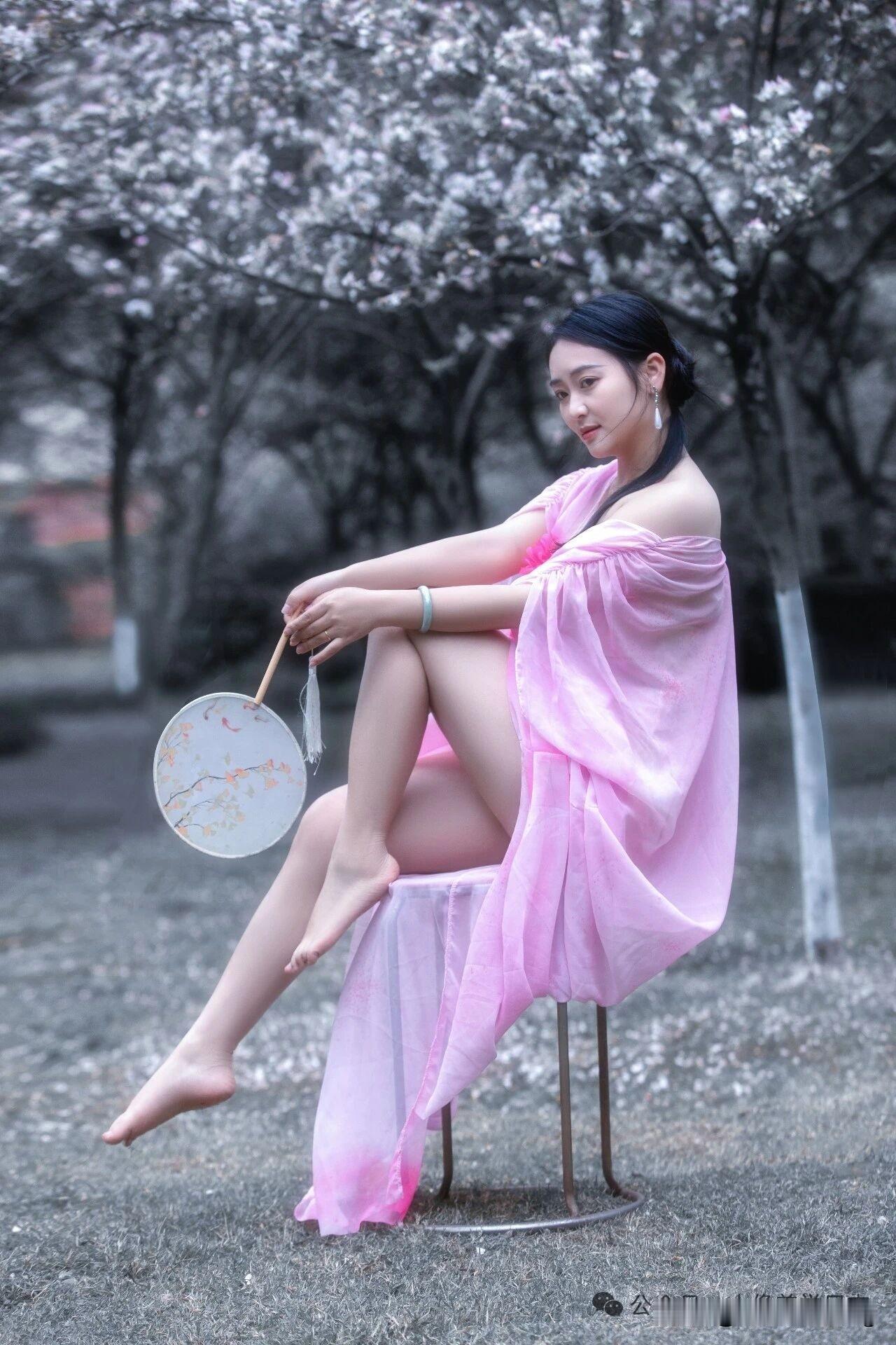樱花树下，粉裙飘飘，手持团扇，悠然自得。粉裙花畔照 湖畔棕裙照 粉裙花畔写真 团