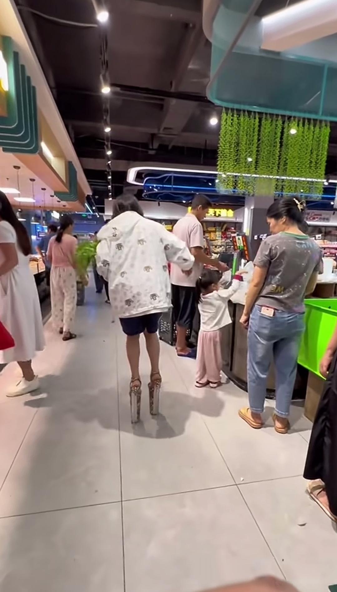 女子脚踩超高跟鞋逛超市，步履晃悠引得路人纷纷避让！
超市里本就人来人往，一名女子
