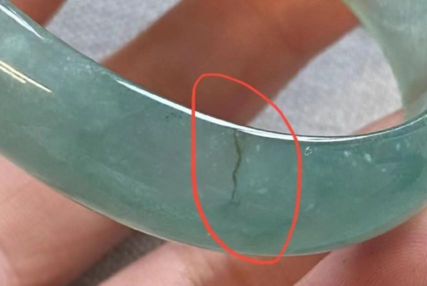 新疆乌鲁木齐，女子在玉器店看中一只手镯，店员提醒她不要拿托架，要拿手镯，女子不听