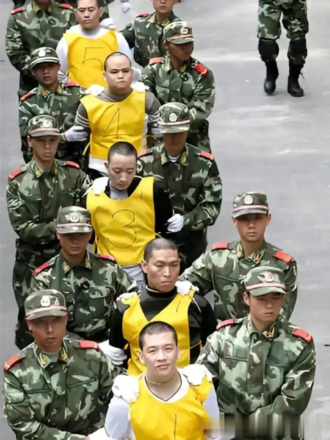 东莞，几名死刑犯正被押往当地的牛山刑场。

一号犯人居然面带笑容，挺帅气的小伙子