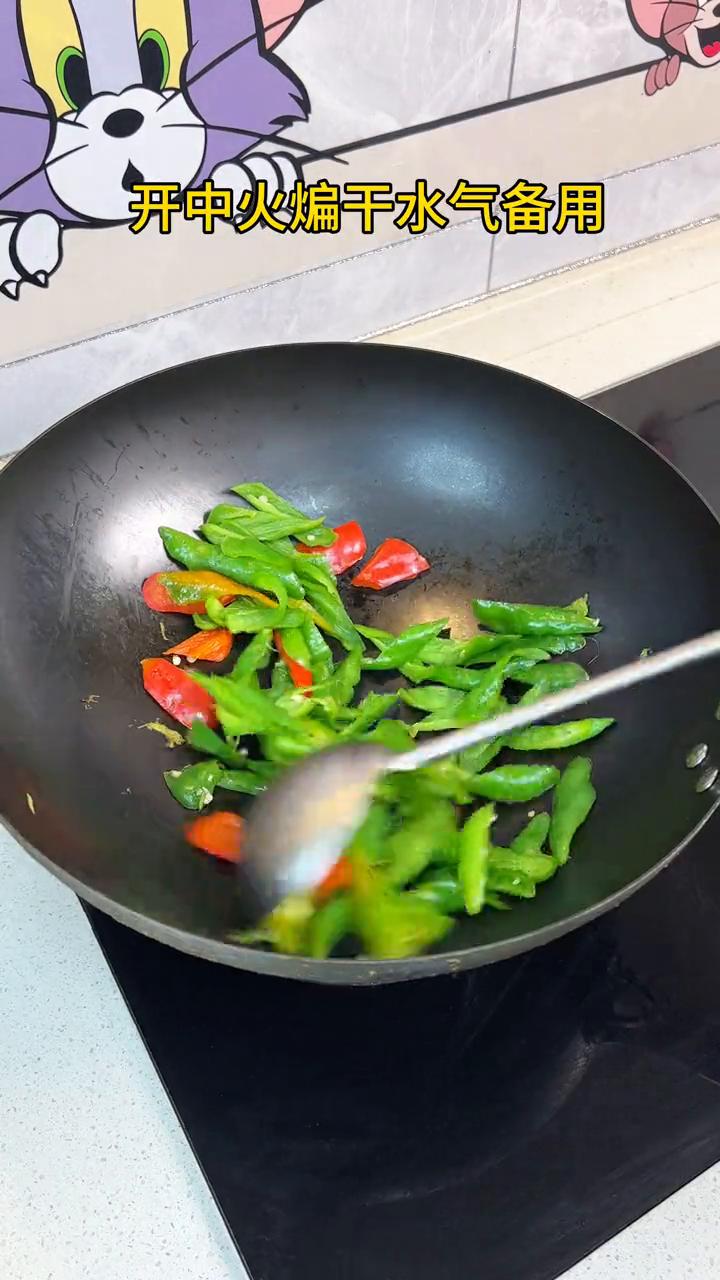辣椒炒肉。
·辣椒直接下锅，开中火煸干水气备用。
·另起锅下入肥肉，炒出油脂下豆