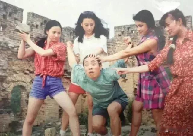 年轻时的张艺谋和一群美丽的女演员一起去长城游玩，被她们捉弄着开心地打闹，场面欢乐