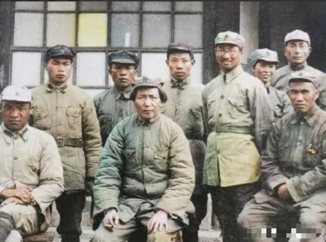 1937年初，红军总部迁驻延安。在黄土坡的窑洞前，毛主席、朱老总与中央工作人员留
