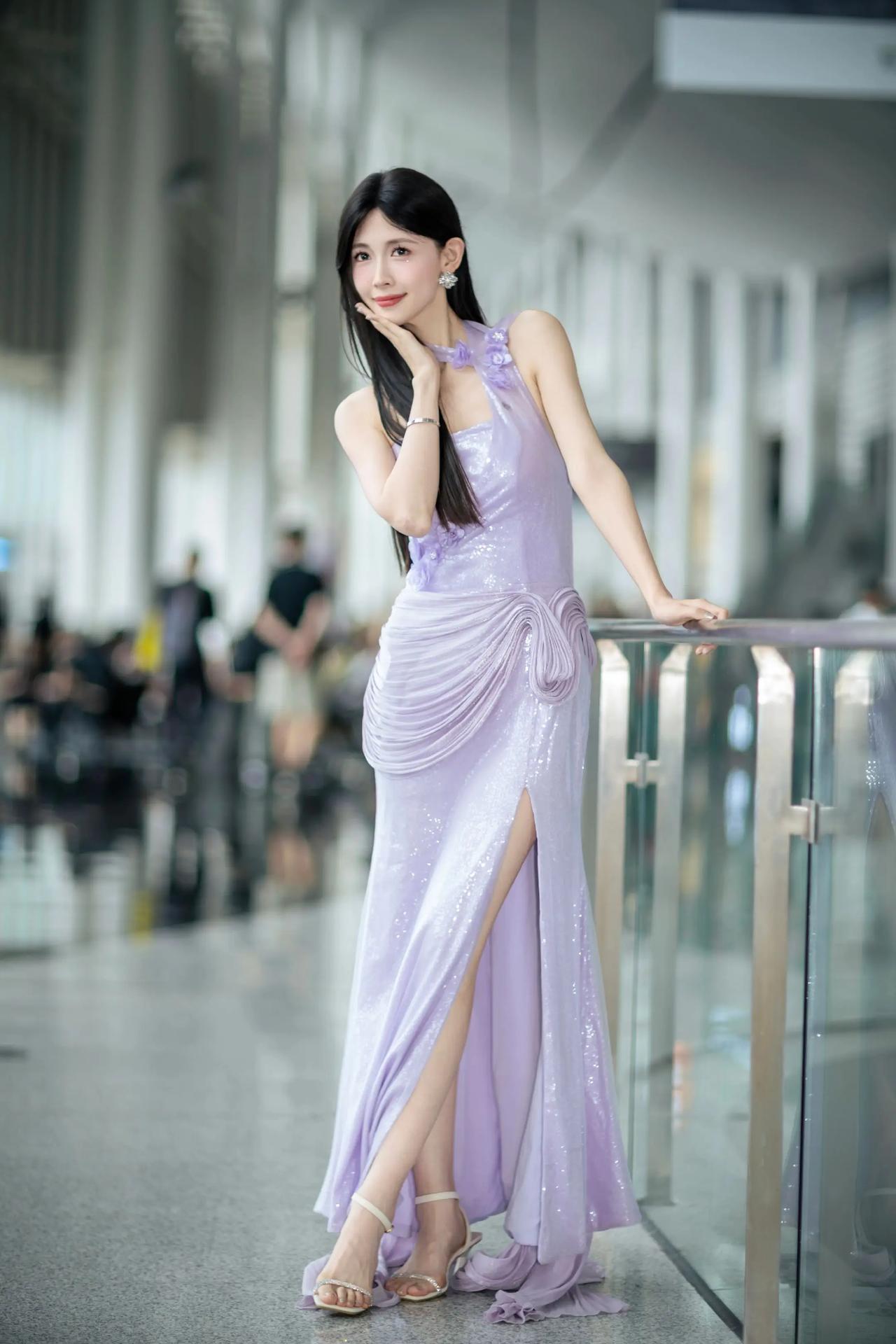 玻璃栏杆的凉意透过指尖传来，她微微侧身，让裙摆的褶皱在空气中划出优雅的弧度。紫色