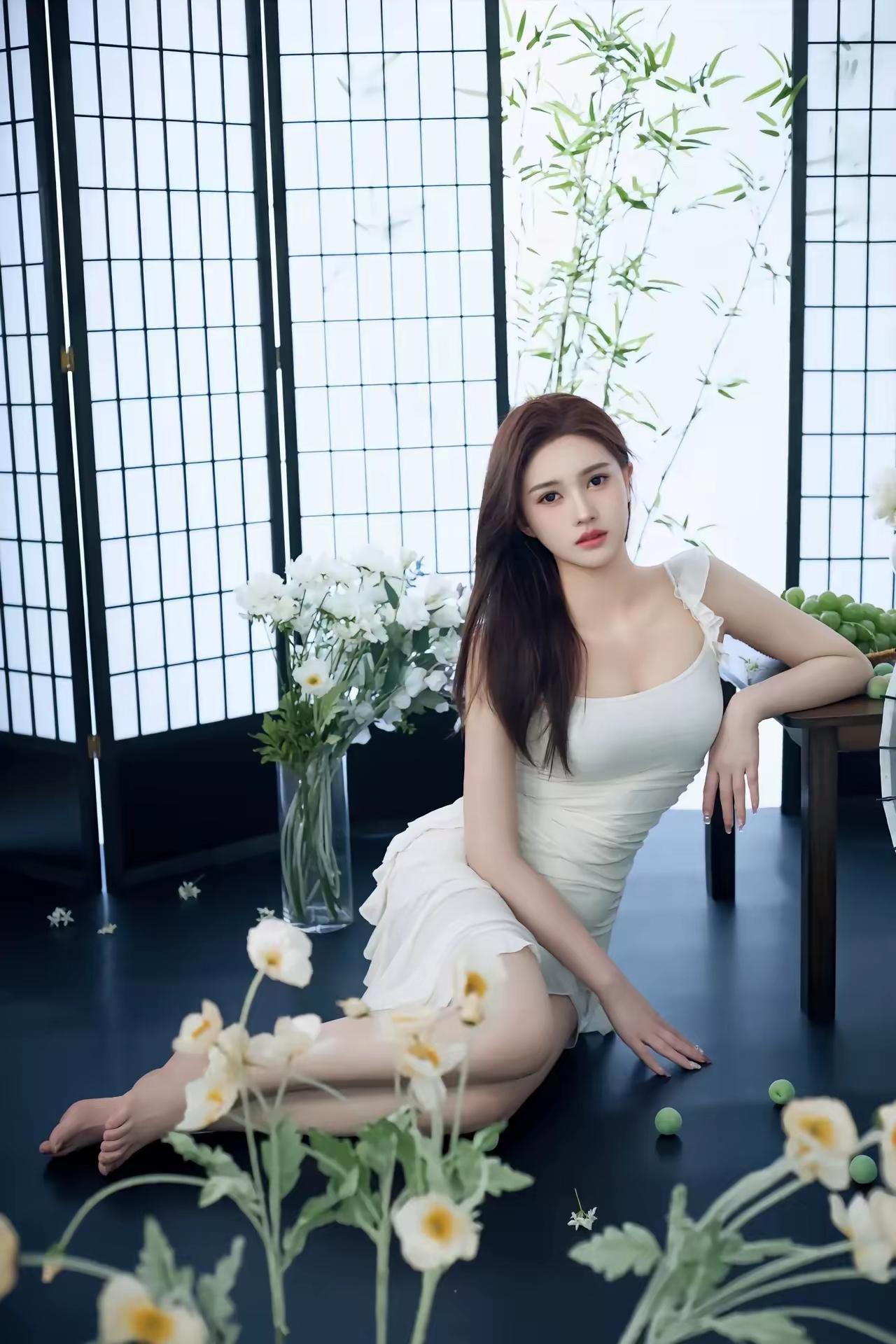 优雅白裙少女，静坐花丛间，自然光下尽显柔美。