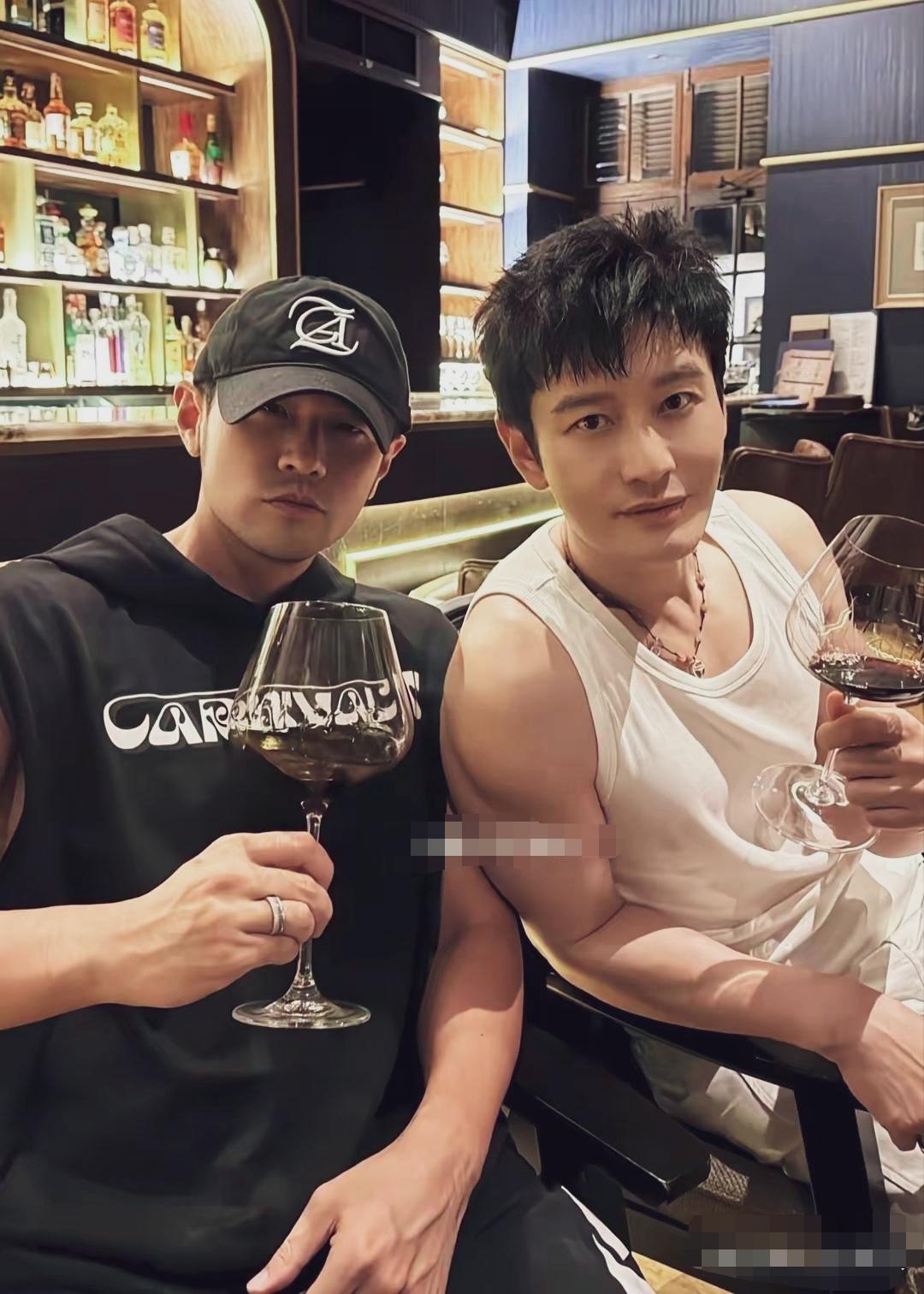 周杰伦黄晓明泰国曼谷一家酒吧小聚，举杯碰杯，变换姿势摆拍。
47岁周杰伦图中身着