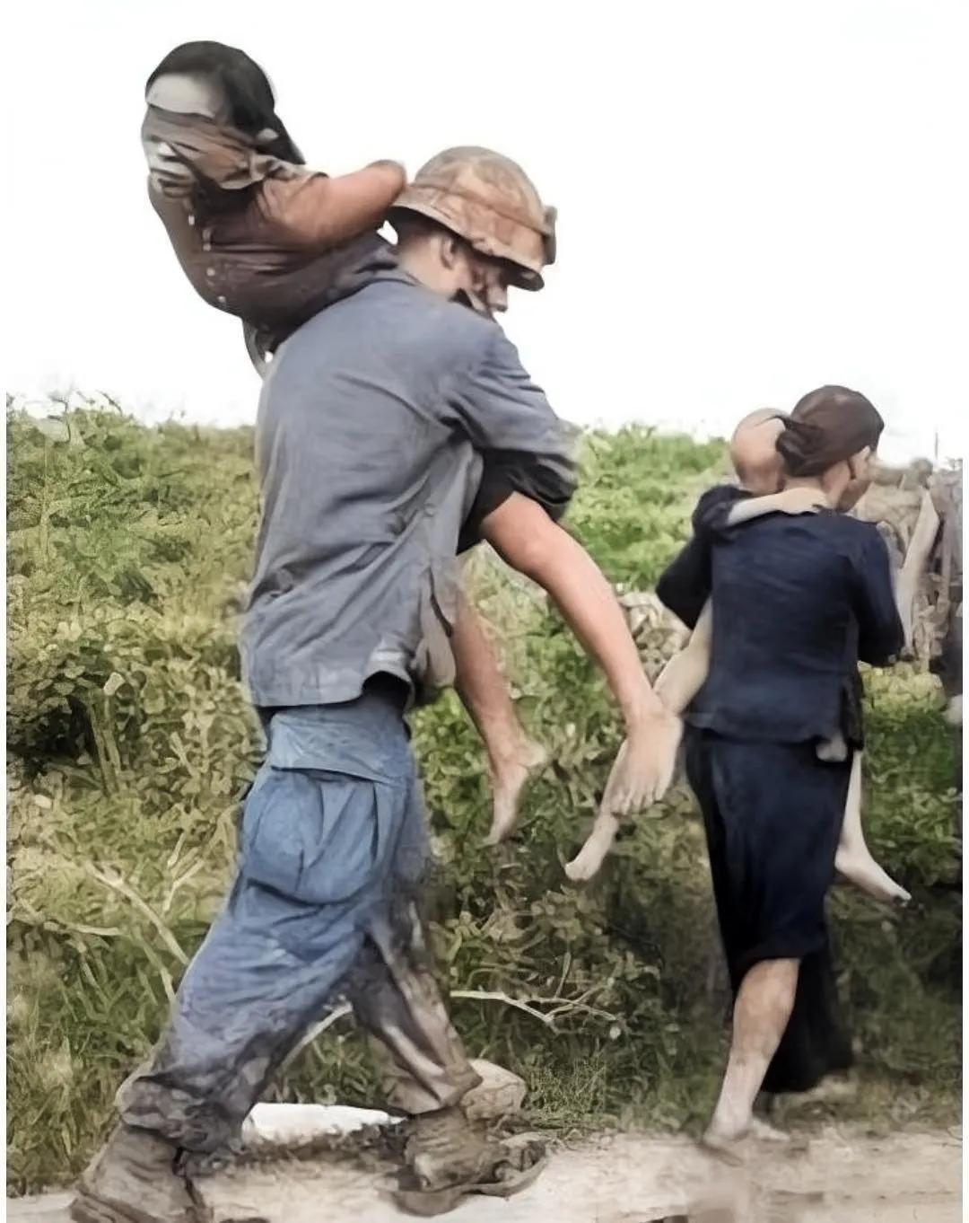 1971年越战期间，被美军俘虏的北越女游击队员，被美国大兵扛在肩上。
这个女游击