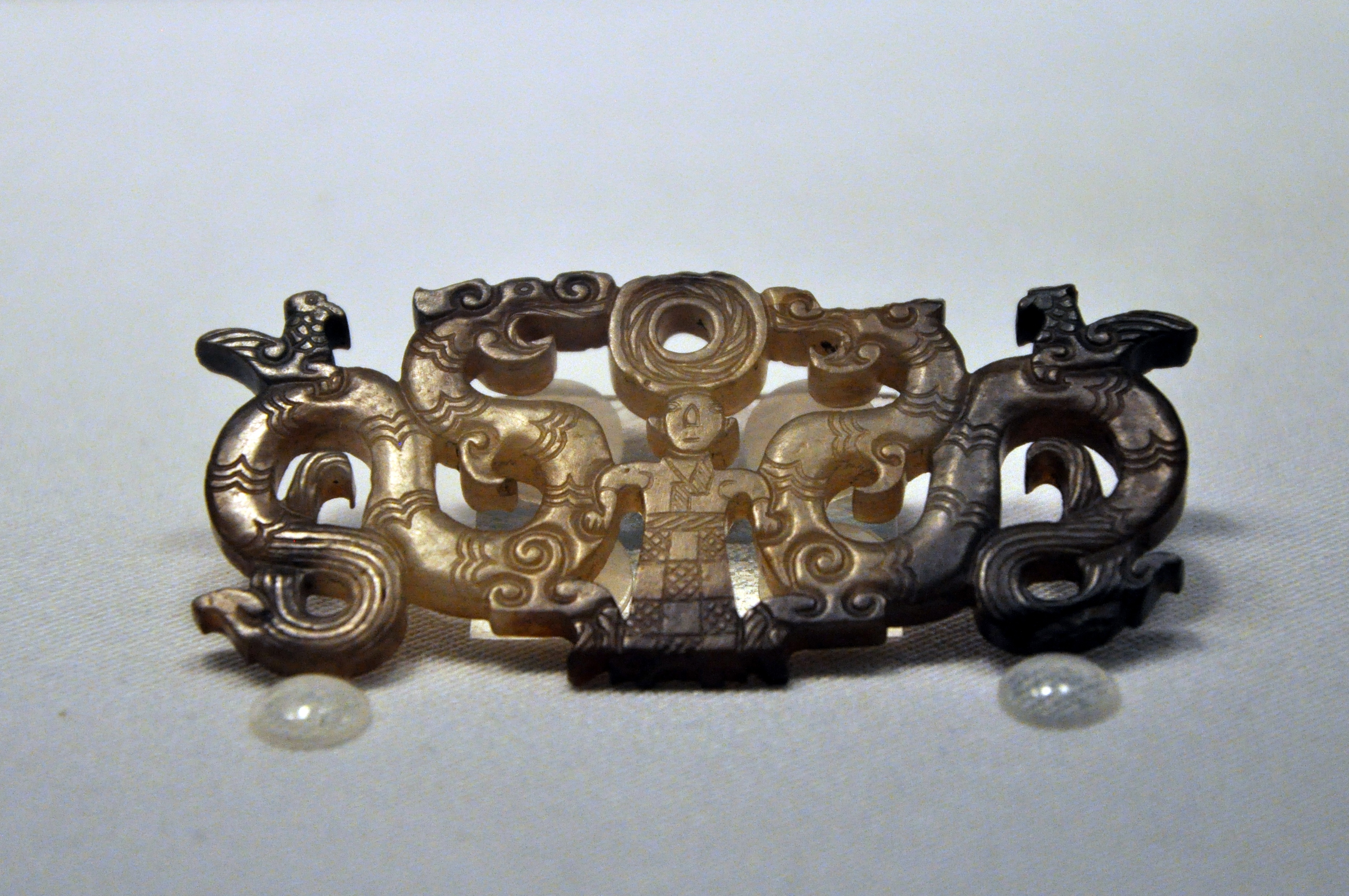 湖北荆州博物馆藏荆州院墙湾战国楚墓出土:神人扶两龙形玉佩 可惜了右侧的龙首有残 