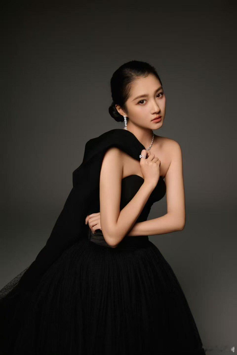 关晓彤黑色纱裙如暗夜绽放的墨莲，旋转间裙摆扬起星河流淌。礼帽半遮眼眸藏着月光心事