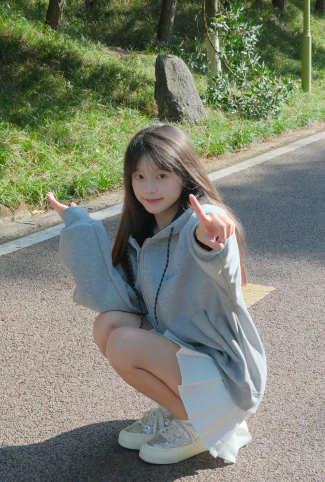 元气少女在花草丛林的马路上蹲着美图，这画面简直不要太美好！就像安安崽的清纯甜美写