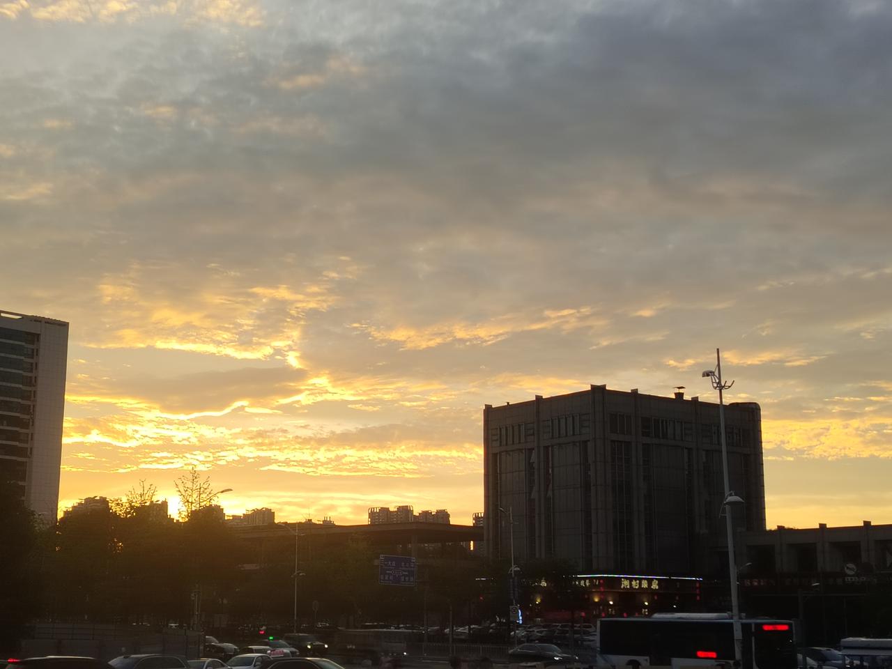 盛夏的长沙，被一场绚烂的晚霞温柔拥抱。金灿灿的余晖如倾泻的碎金，肆意洒满无垠的天