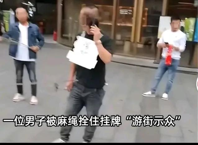 男子被挂强奸犯牌子游街示众，脖子上挂着一个牌子，
写着三个字强奸犯，
脸上还抹着