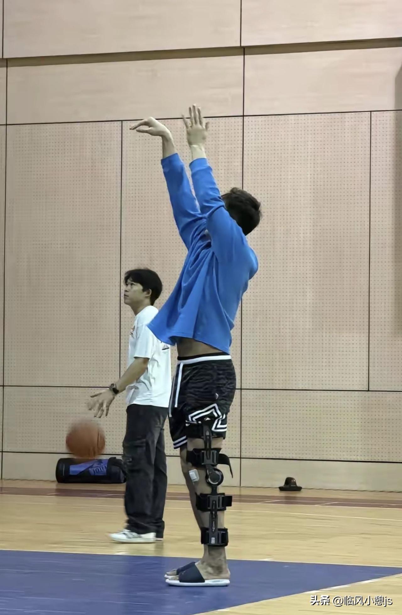 郭艾伦左腿佩戴着铰链支具，身影却依然坚定地伫立在球场练习投篮。每一次出手，都承载