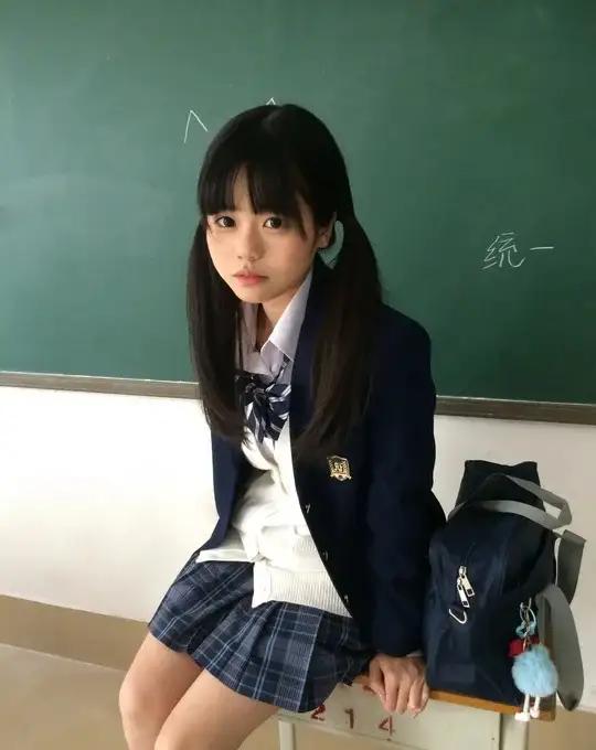 教室里的女生穿着校服，坐在讲台边。教室美女 课堂美照