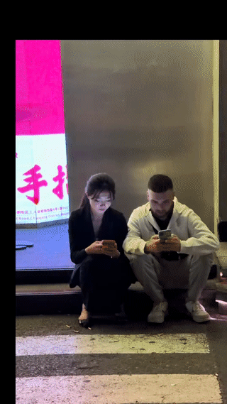 北京三里屯街头。
有网友拍到一名年轻漂亮的女子正和一名外国男子坐在一起聊天说话，