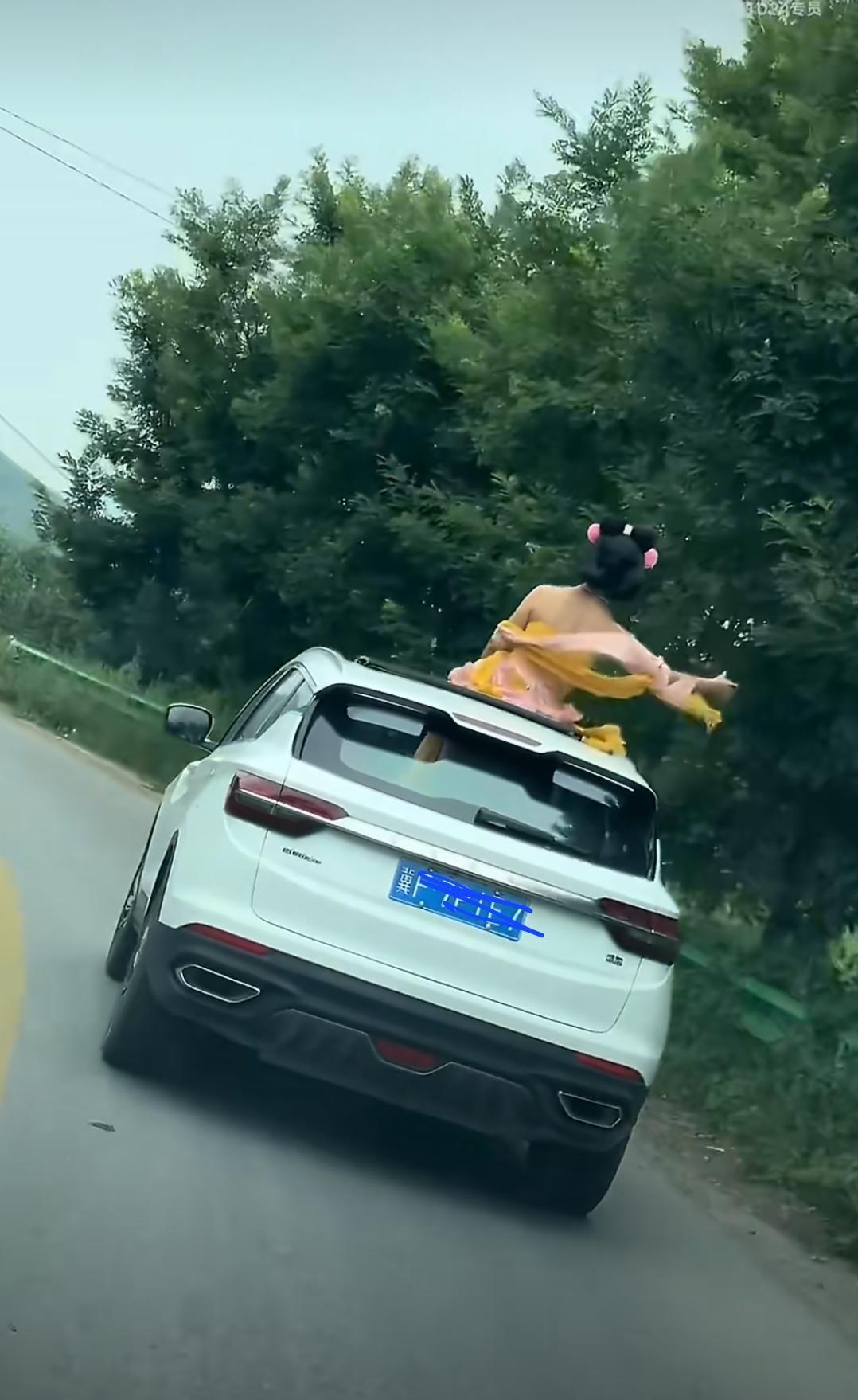 燕赵之地多猛士啊，听说这是河北易县那边的事情。
开着车把天窗打开，小姑娘探出半个
