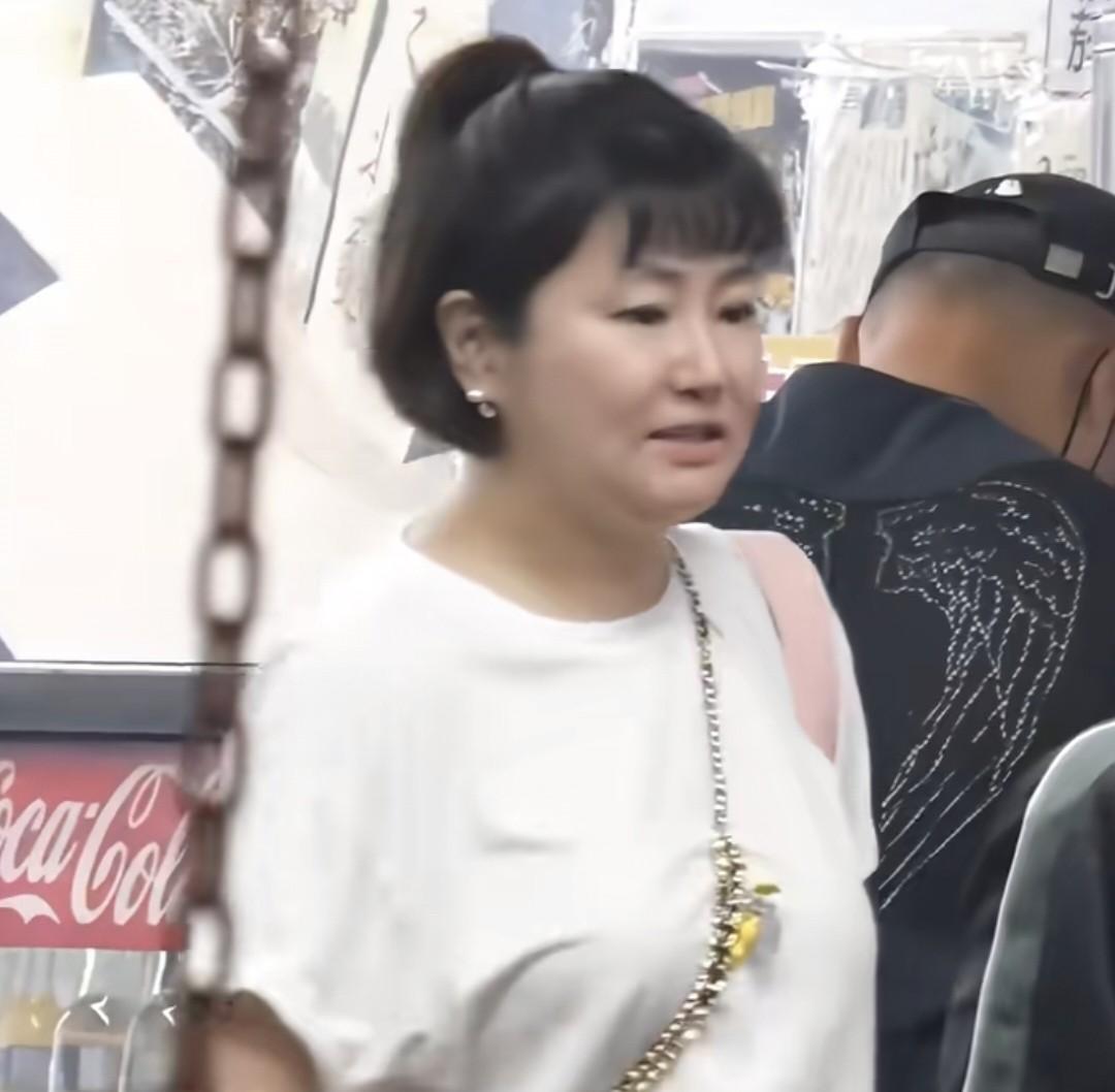45岁剪了短发，穿着白露肩T恤，斜挎手机，大大方方露出双下巴——任家萱这次带孩子