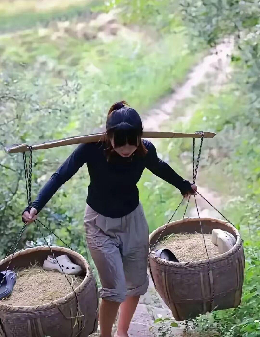 有人说，这是摆拍！

一个女人根本不可能挑得起两箩筐的稻谷。

但是，我是经历过