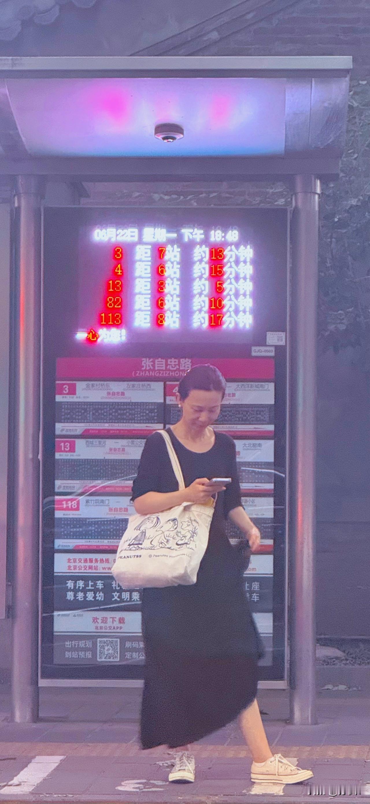 分享一下你随手拍下的照片北京平安大街公交车站，一位美女看着手机偷着乐呢！中国人的