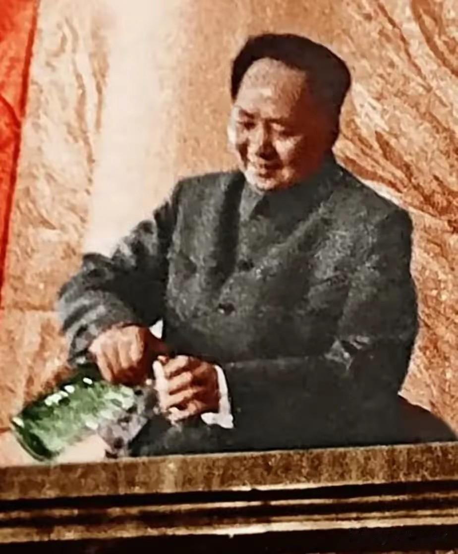 画面中毛泽东身着中山装，坐在主席台桌前，手持绿色玻璃水壶向杯中倒水，面带温和笑意