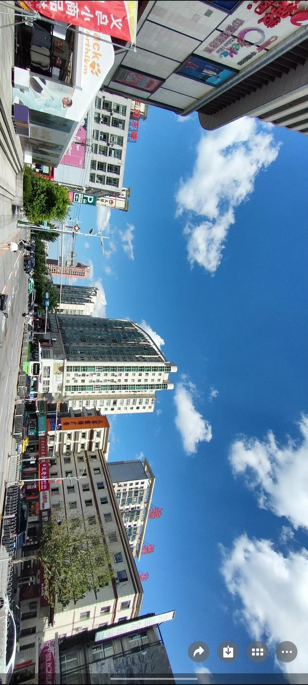 蓝天白云下的繁华街景，现代与自然的完美融合。