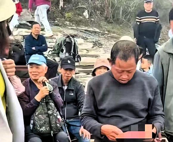 贵州梵净山，两个轿夫蜷在石阶边，眼巴巴盯着游客一个个走过，没人停下。年过五旬的老