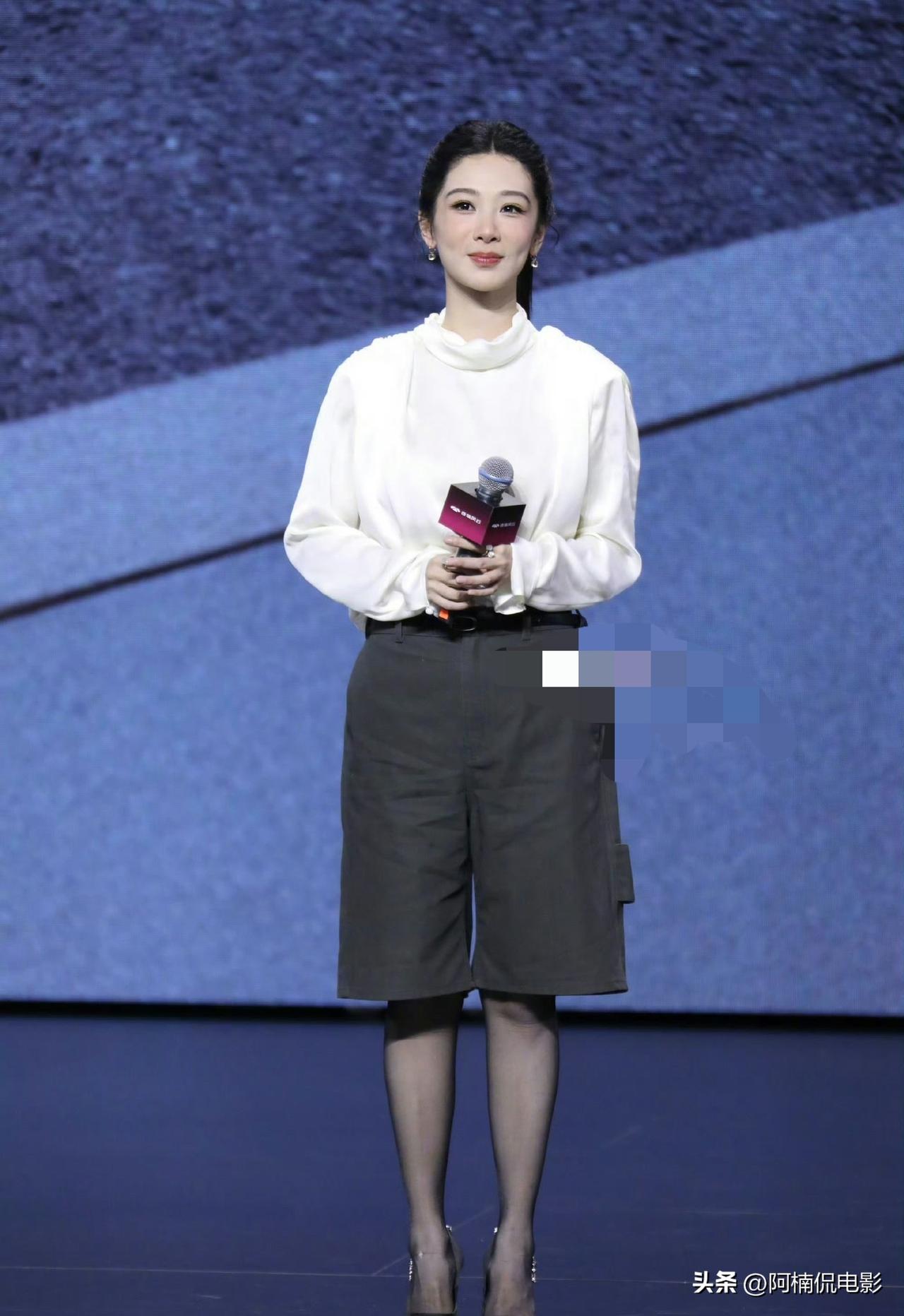 杨紫现身汽车代言活动，高马尾造型清爽利落，极大拉长脸部线条。上身是缎面堆领白衬衫