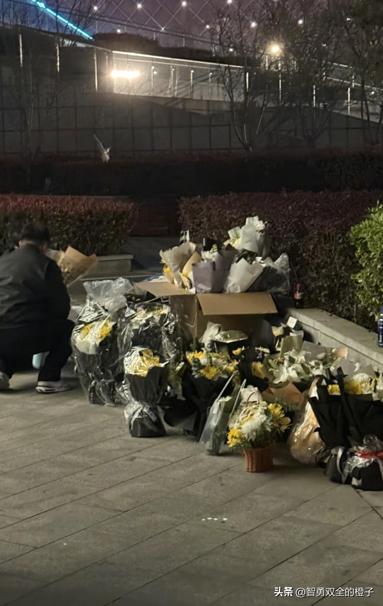 张雪峰公司楼下堆了很多鲜花，都是黄色和白色的菊花，看得人鼻子发酸！

有附近人亲