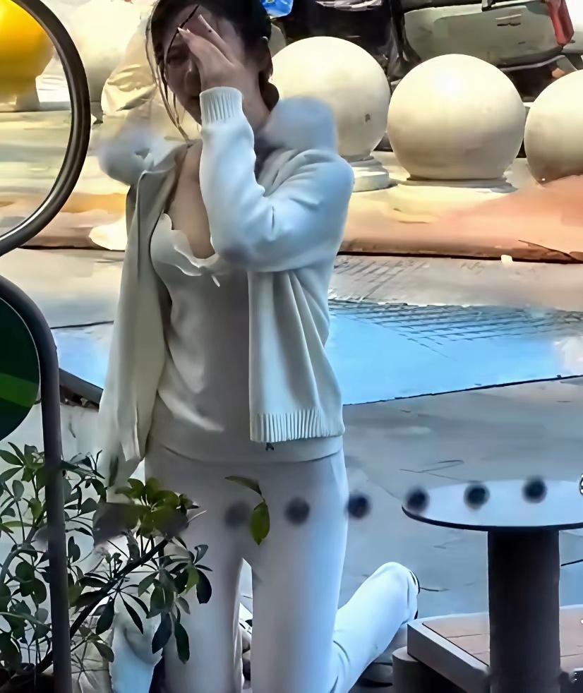 上海，5月16日，一个有些袒胸露乳的年轻姑娘，当街跪在一个男子面前，男子坐椅子上