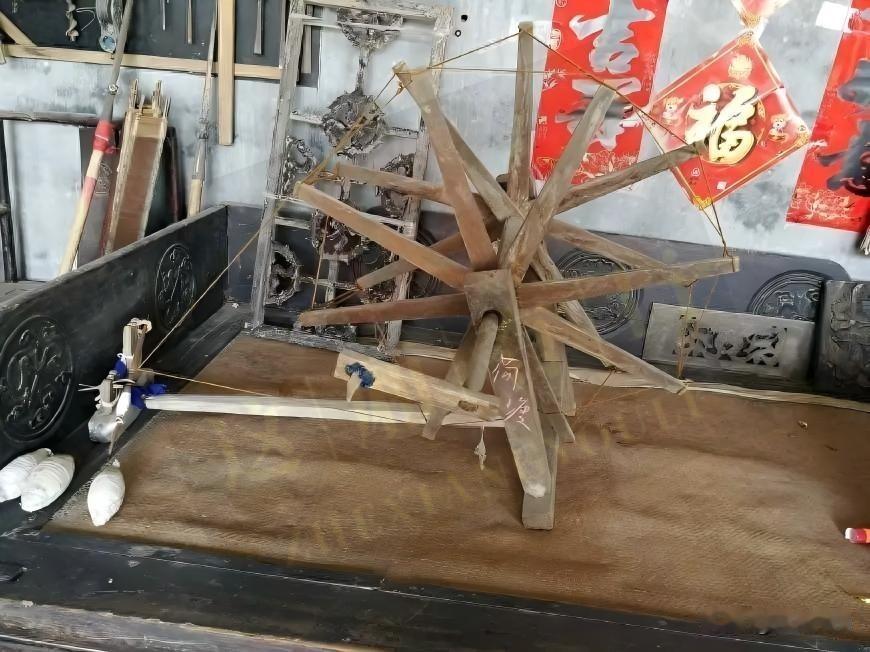 老木轮静静立着，木棱磨出温润包浆，牵线轻垂，伴着细碎棉絮，藏着从前晨昏里的指尖烟