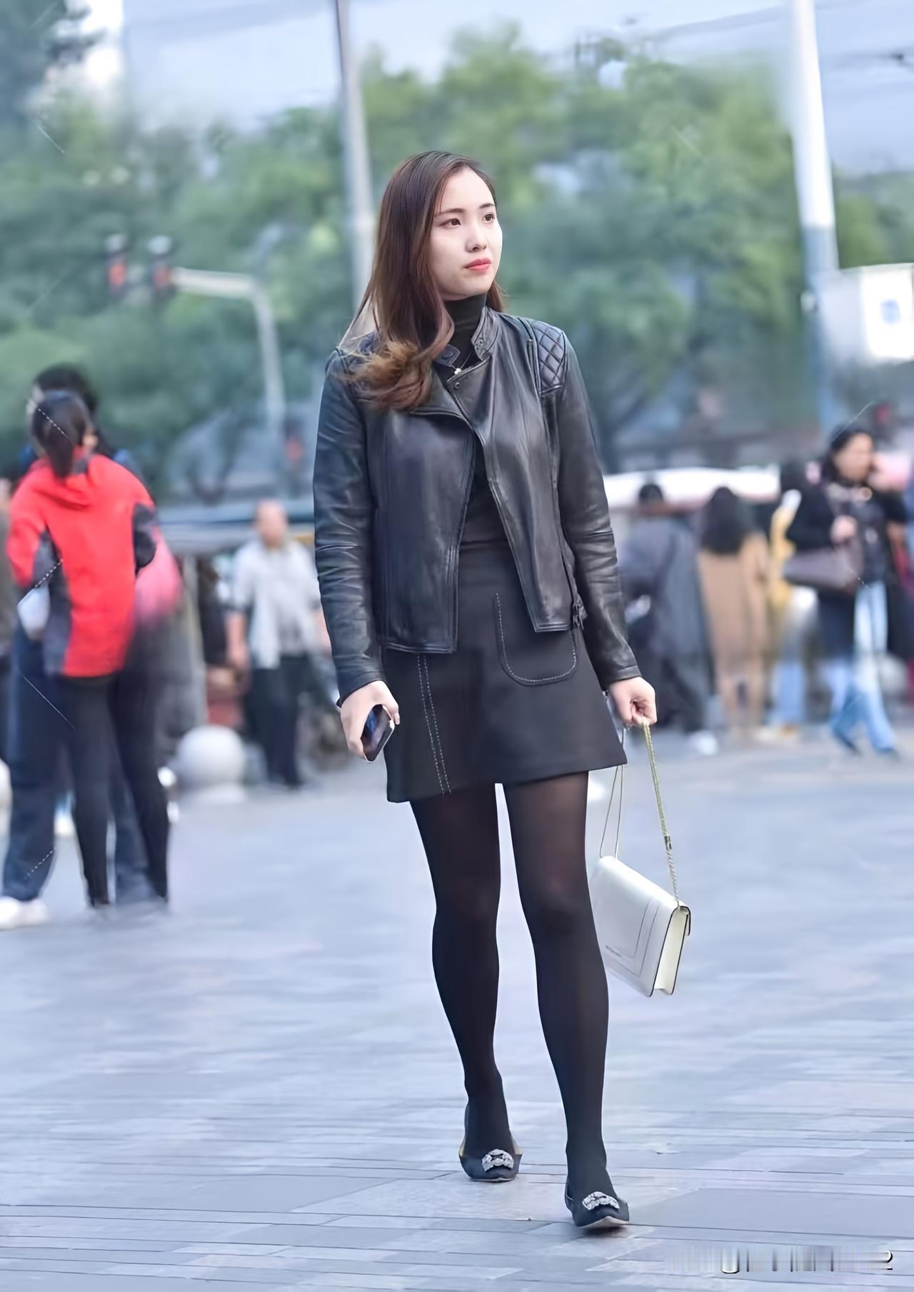都市街头时尚穿搭，黑色皮衣短裙，自信步伐