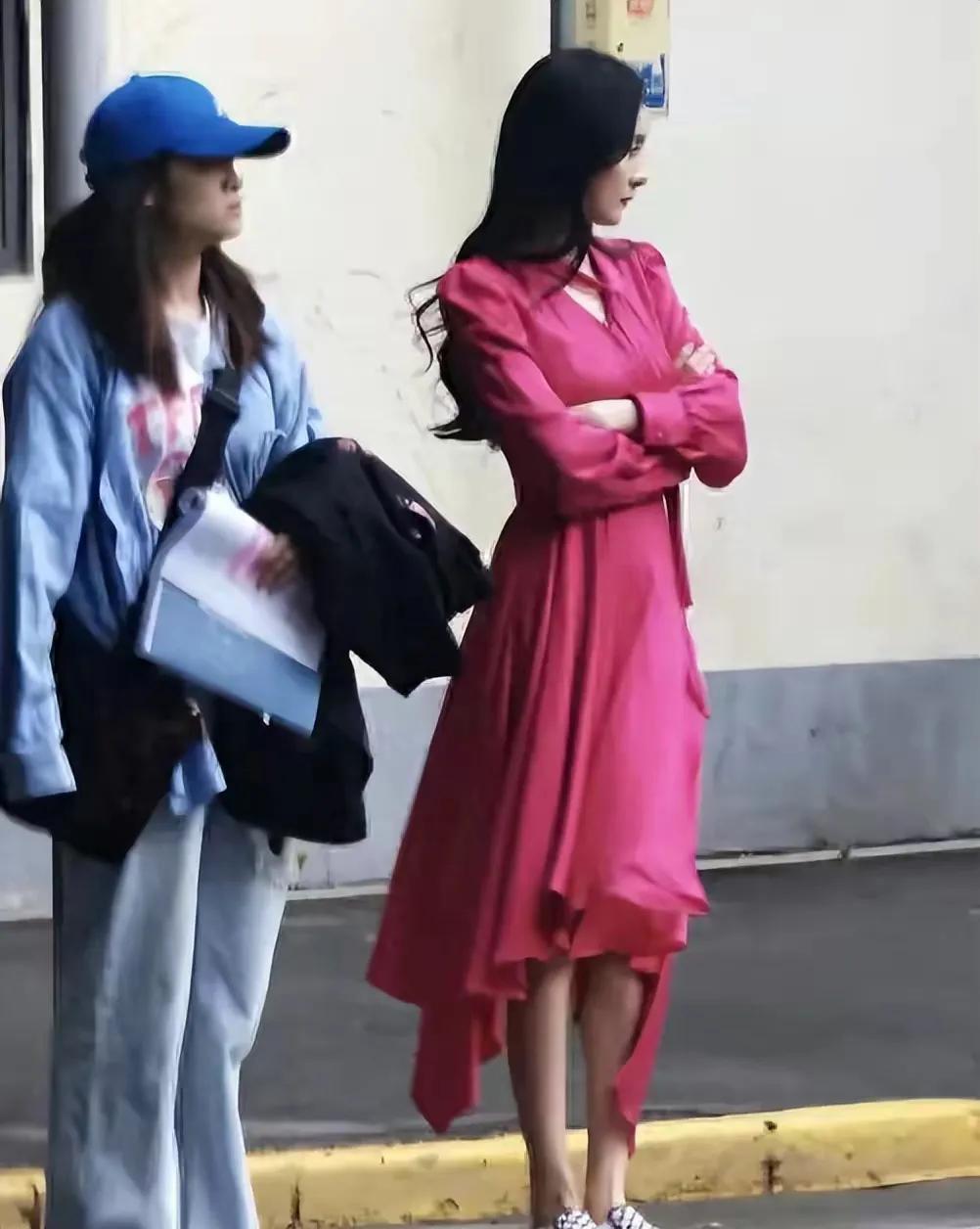 路人镜头下的杨幂，穿玫红色长裙魅惑冷艳，站在路边也有明星范，果然是气场超强！
玫