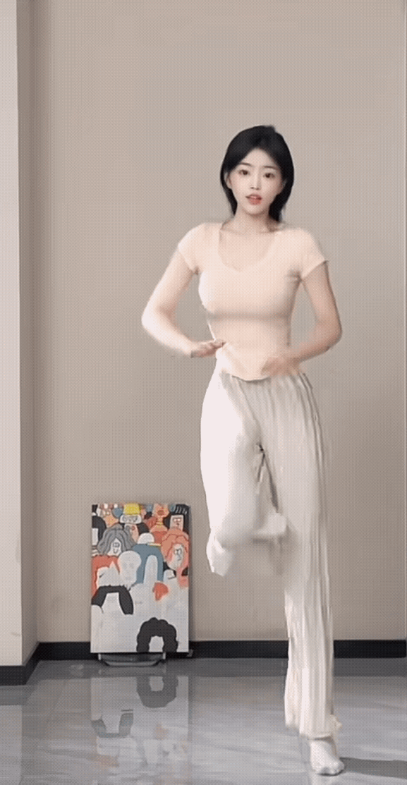 这姑娘正在做踢腿运动呢。在家做舞蹈真是服了。