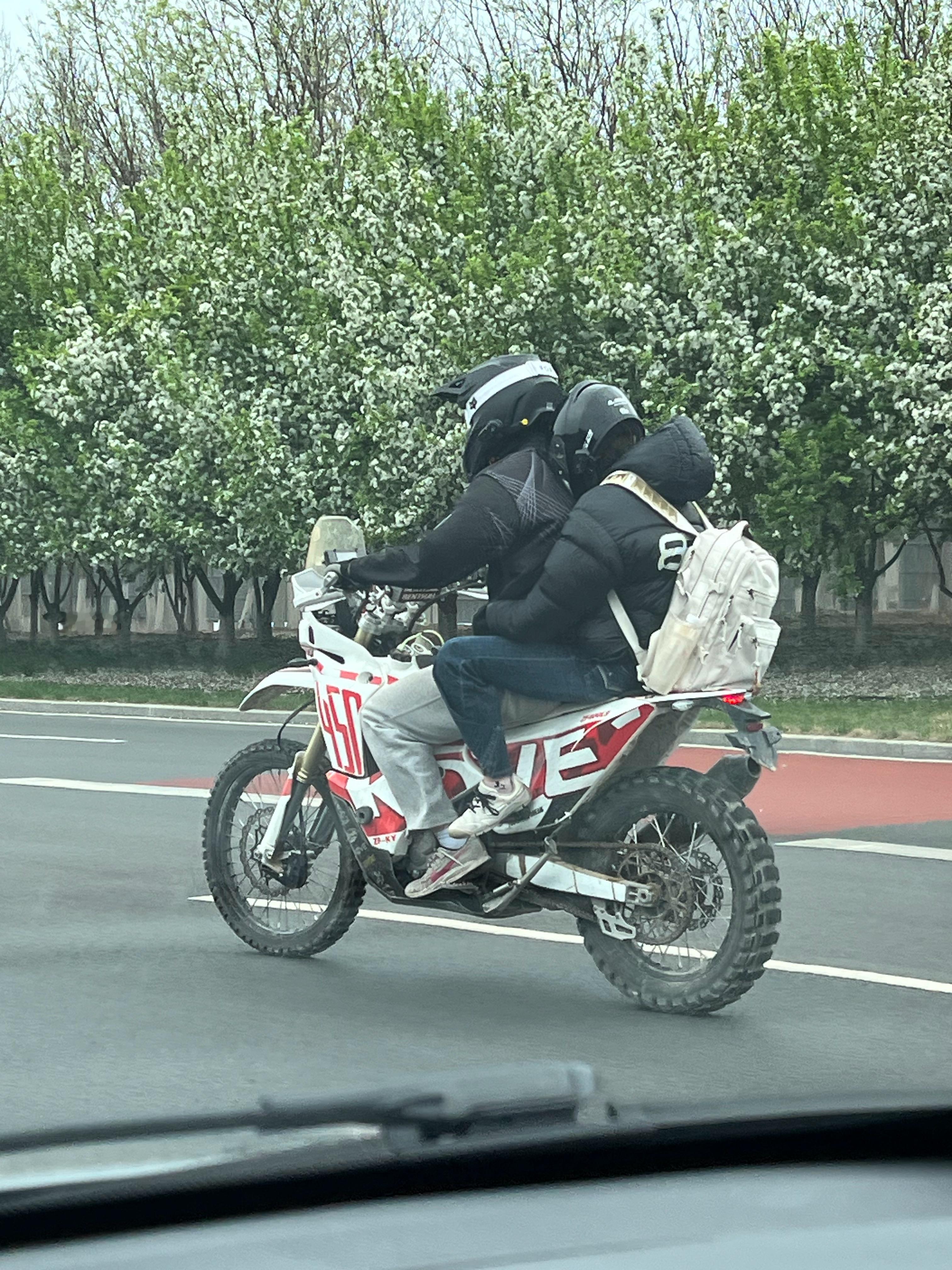 刚才路上偶遇的，骑摩托的两个人后座坐姿有点惨～再一想，刚才还下了大雨 ，更惨了 