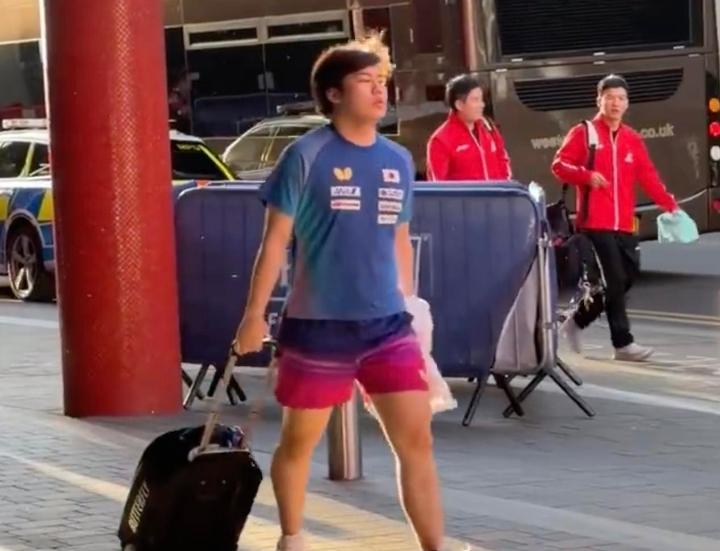 伦敦街头，松岛辉空拖着行李箱，穿着短袖短裤，眼神冷漠，和国乒众将擦肩而过，别说主