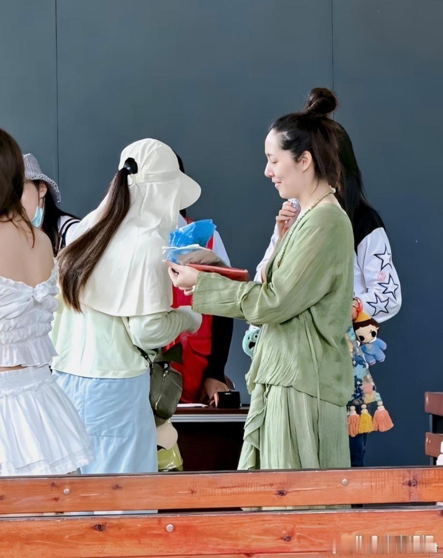 44岁郭碧婷和家人现身西双版纳旅游被偶遇，她穿着一件绿色连衣裙，扎着丸子头，看起