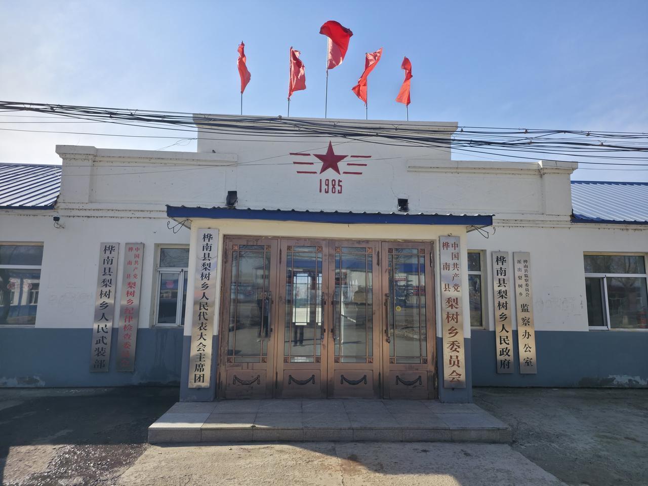 一栋悬挂着红旗的乡村政府建筑，它建于1985年，虽历史不算久远，却也见证了一段过