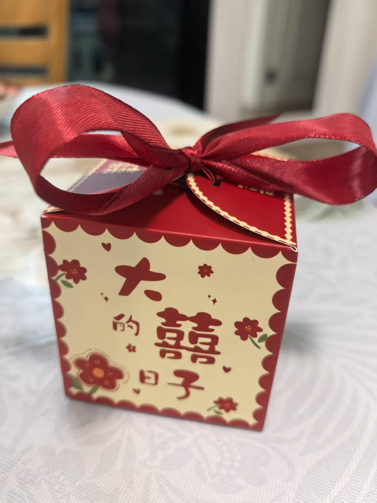 望着那印着“大囍的日子”的红色糖盒，手中500元红包似有千斤重。曾几何时，随礼是