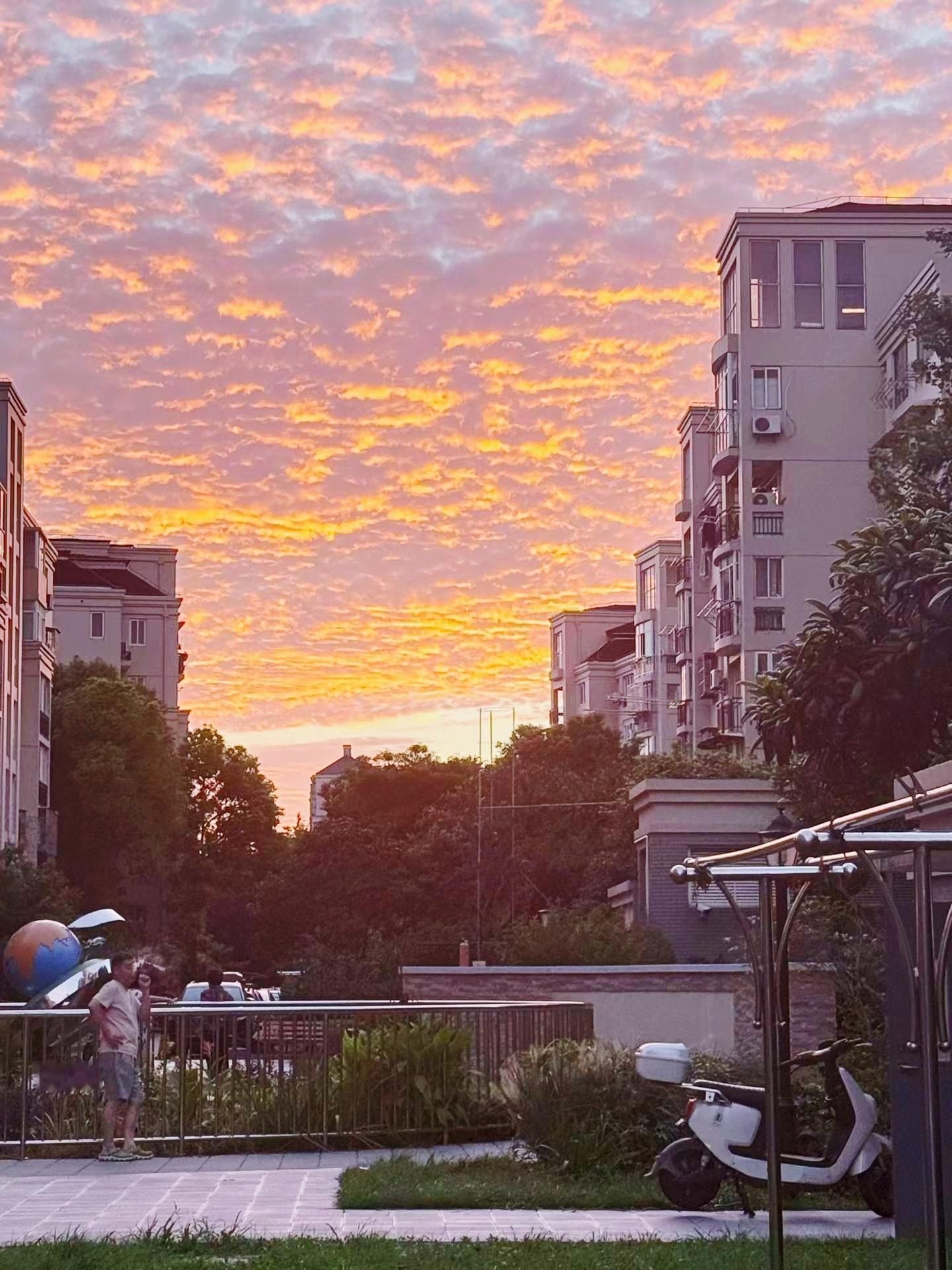 上海晚霞夕阳一点点沉下去将整片天空染成橘色鱼鳞般的云朵铺满了整个天空晚风裹挟落日