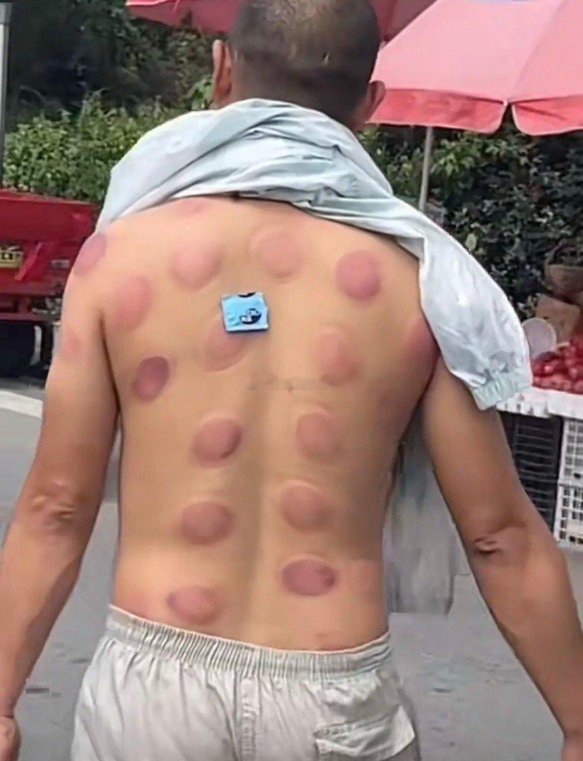 笑不活了，这位大哥刚保健完，左手提着西瓜右手提着猪蹄走在回家的路上。后面的路人看