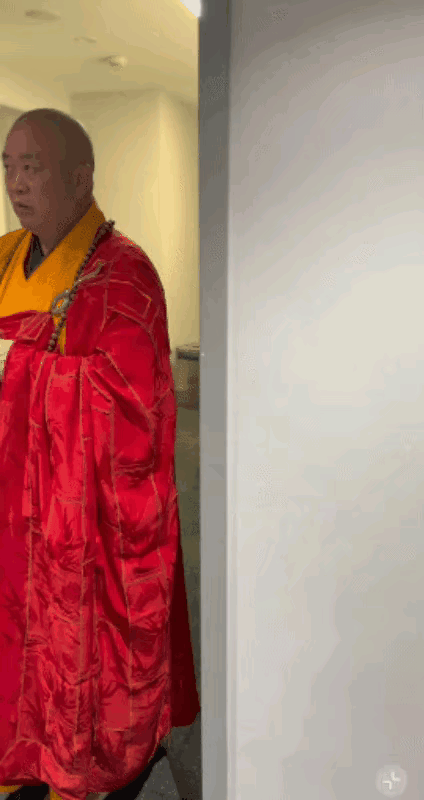 红衣露肩美女从少林方丈释永信面前经过，方丈大师的眼睛放亮，直勾勾的盯着美女，仿佛