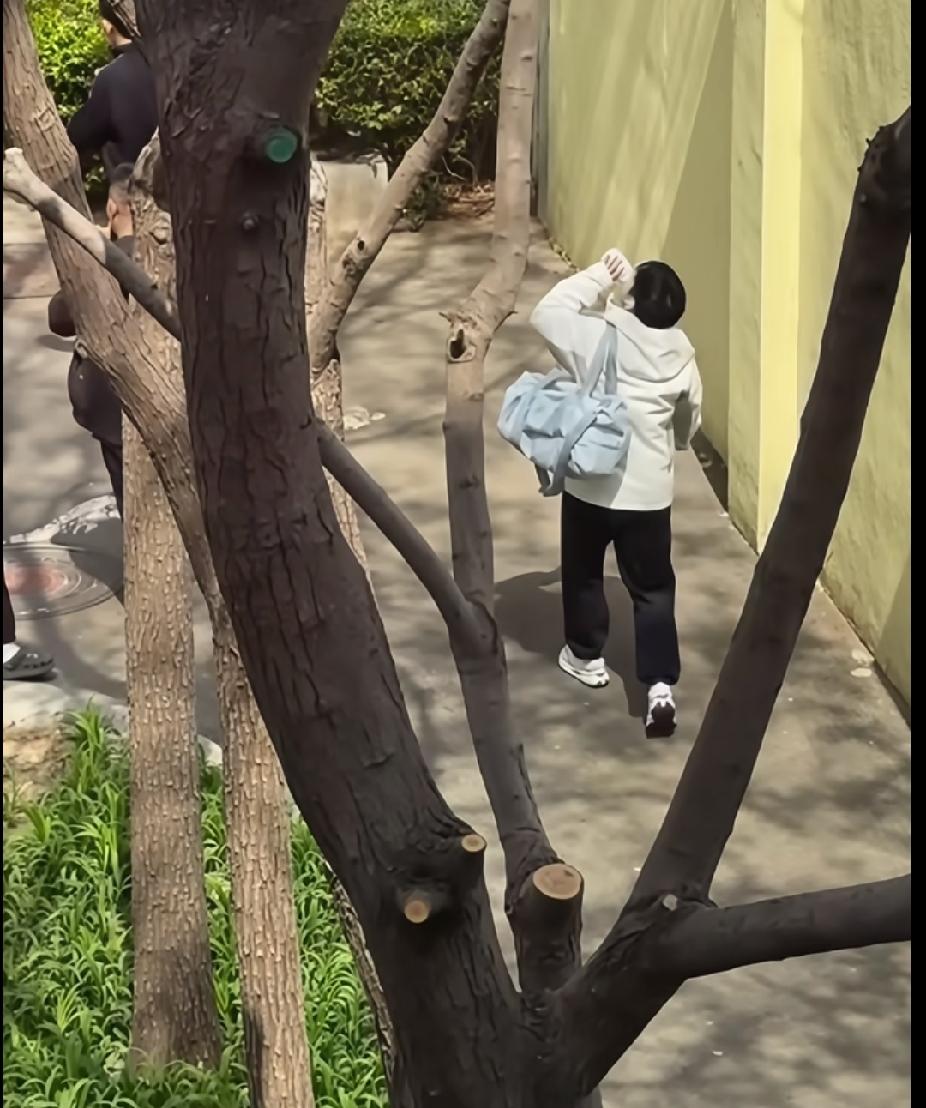 刷到抓拍的莎莎，太会拍啦！
穿着白白的外套，浅蓝色的大包单肩挎着，小路上一边往前
