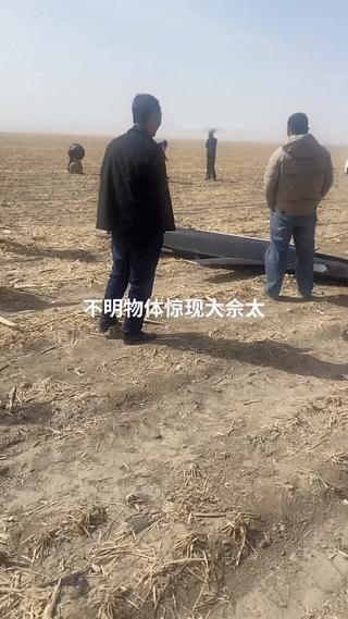 农田里突降“不明飞行物”？
村民们十分好奇的赶到现场查看。
这东西看起来有点像是